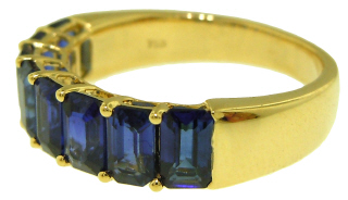 18kt yellow gold shared prong emerald cut sapphire band.