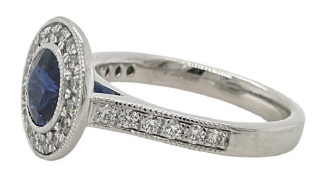 14kt white gold bezel set sapphire and diamond ring with milgrain edge.