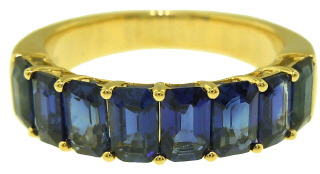 18kt yellow gold shared prong emerald cut sapphire band.