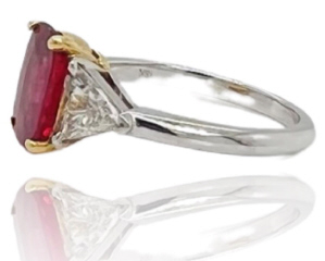 18kt white and yellow gold oval ruby and trillion diamond ring