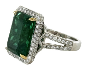 18kt two tone emerald cut emerald and diamond halo ring.