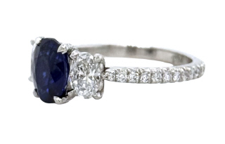 Platinum oval sapphire and diamond 3-stone ring with diamonds on the shank.