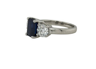 Platinum emerald cut sapphire and round diamond 3-stone ring